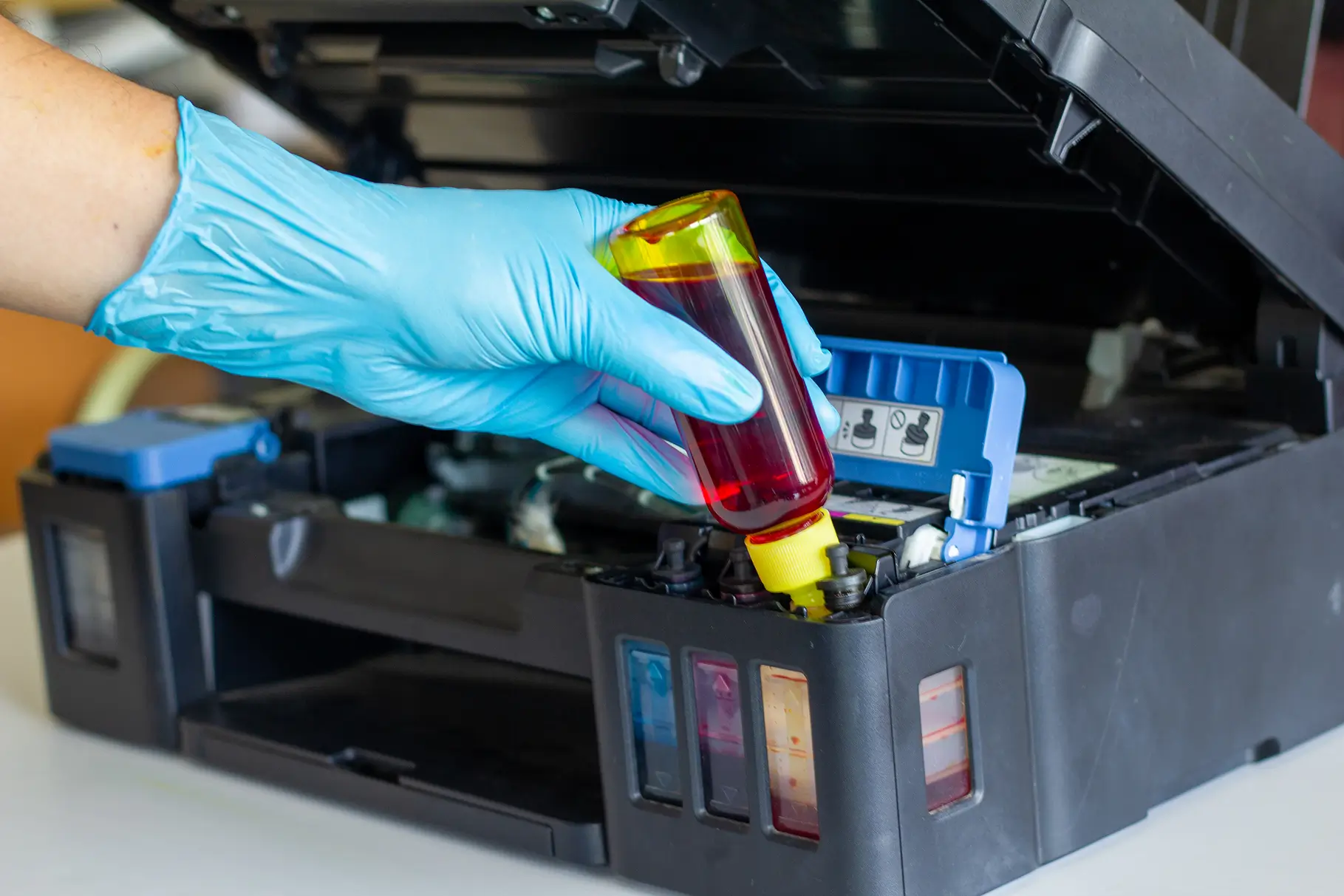Technician servicing a printer cartridge during repair